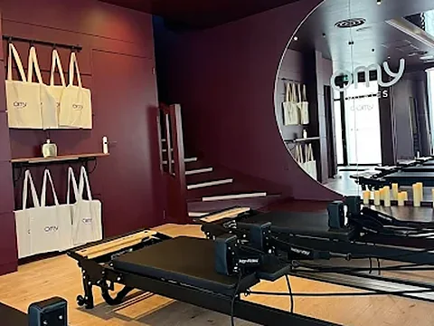 Studio Reformer OMY Pilates, sacs en toile et miroir rond
