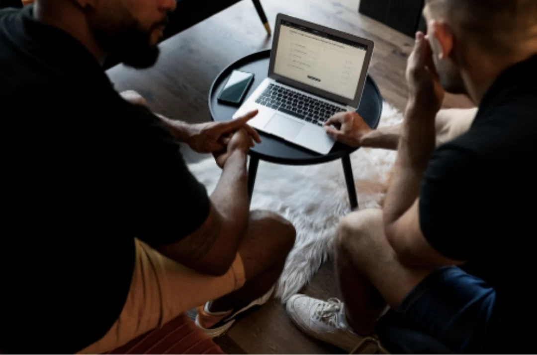 Deux coachs échangent devant un ordinateur portable sur la plateforme en ligne